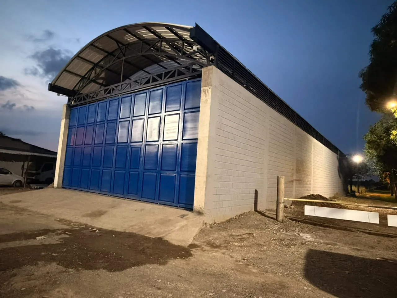 Fachada de la sede de Soditeel en Apartadó: bodega de bloque gris con portón azul y cubierta en arco