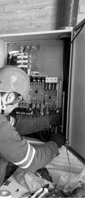 Técnico con casco montando un tablero eléctrico